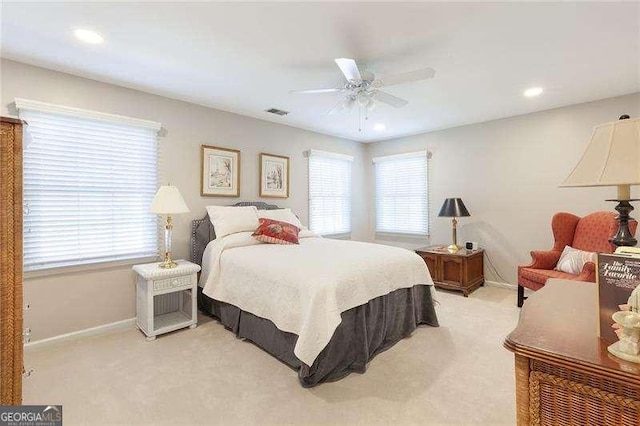 carpeted bedroom with multiple windows and ceiling fan