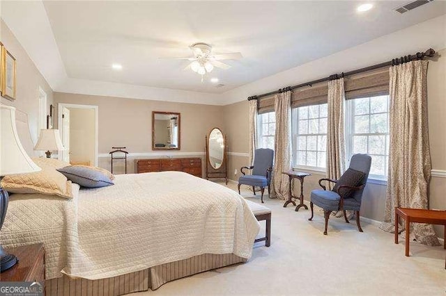 carpeted bedroom featuring multiple windows and ceiling fan