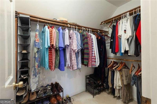 walk in closet with carpet floors and lofted ceiling