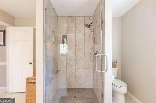 bathroom with walk in shower, tile patterned flooring, and toilet