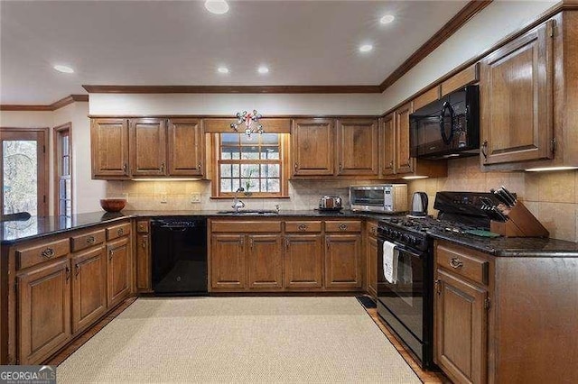 kitchen with sink, a notable chandelier, backsplash, kitchen peninsula, and black appliances