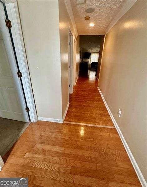 corridor with hardwood / wood-style flooring