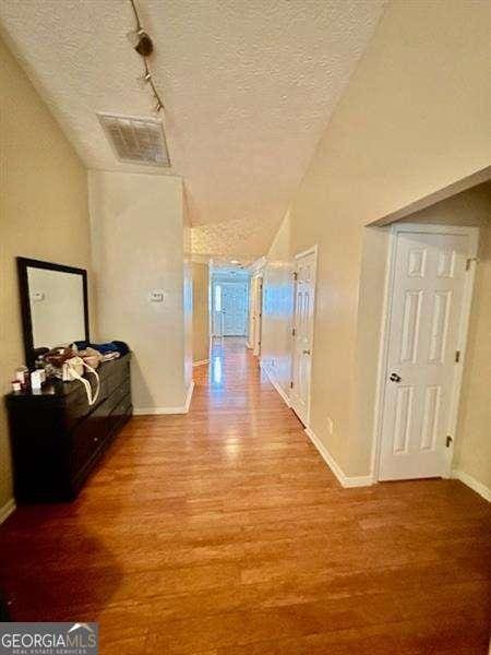 hallway featuring hardwood / wood-style floors and a textured ceiling