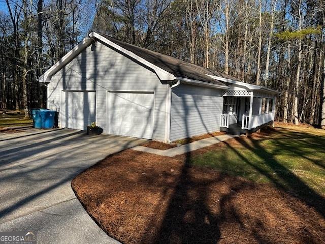 view of property exterior featuring a garage and a lawn