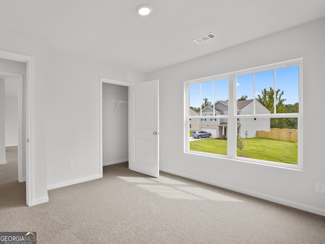 unfurnished bedroom featuring light carpet and a closet