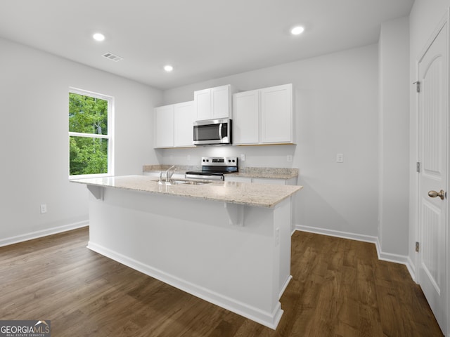 kitchen with appliances with stainless steel finishes, a center island with sink, white cabinetry, and sink