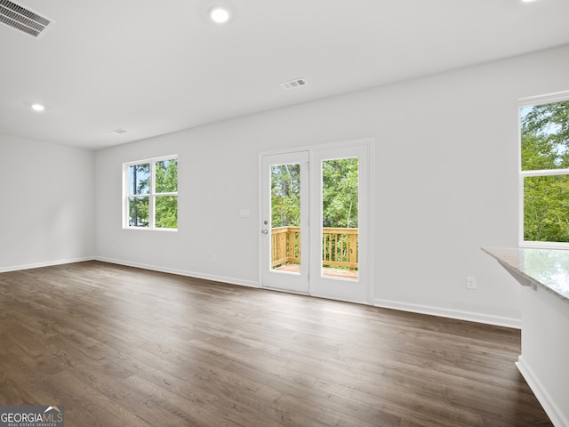 empty room with plenty of natural light and dark wood-type flooring