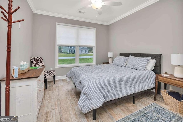 bedroom with light hardwood / wood-style flooring, ceiling fan, and crown molding