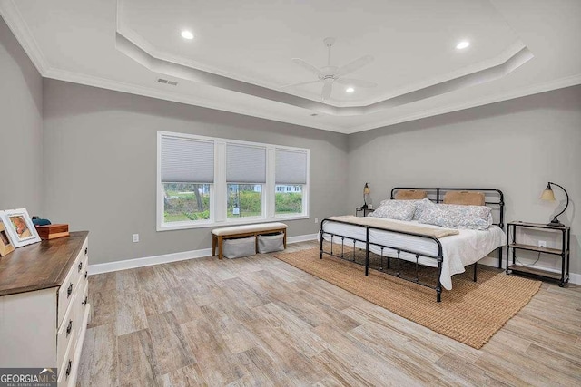 bedroom featuring light hardwood / wood-style floors, a raised ceiling, ceiling fan, and ornamental molding