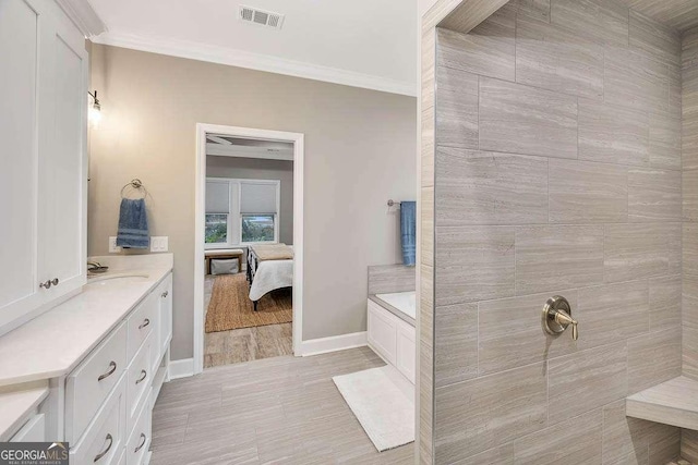 bathroom featuring vanity, ornamental molding, and a bath