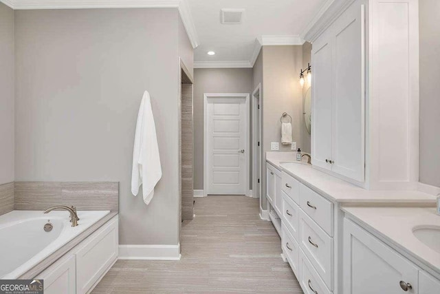 bathroom featuring a tub, crown molding, and vanity