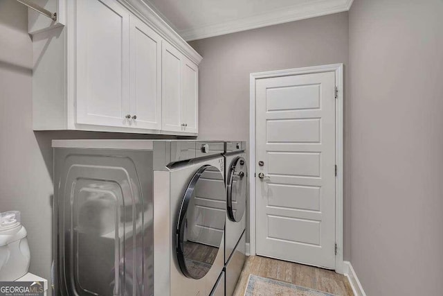 clothes washing area with cabinets, independent washer and dryer, crown molding, and light hardwood / wood-style flooring