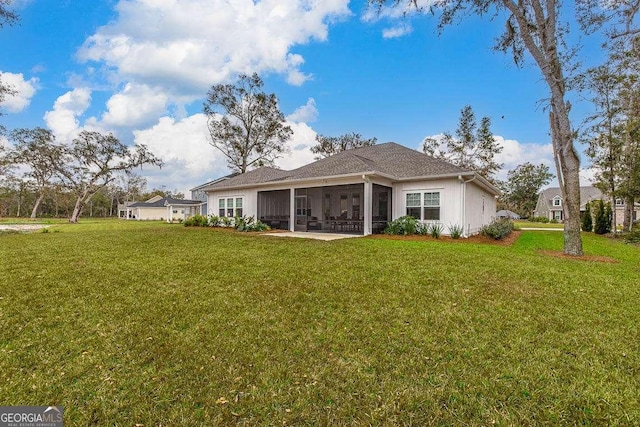 rear view of house with a sunroom and a yard