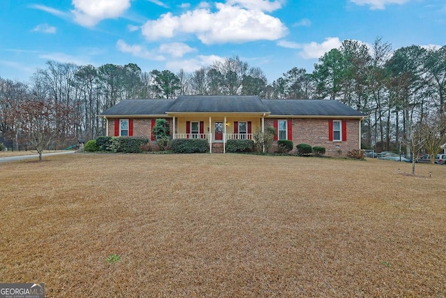 ranch-style house featuring covered porch and a front yard