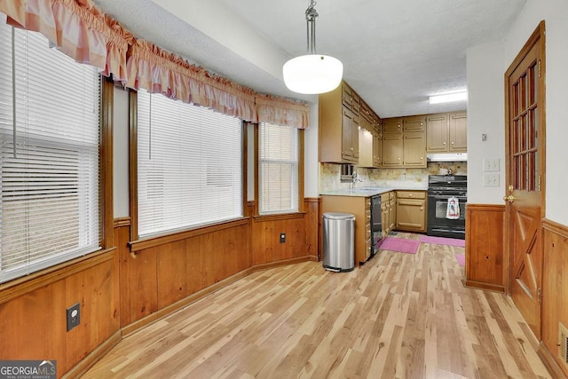 kitchen with backsplash, sink, black appliances, pendant lighting, and light hardwood / wood-style flooring