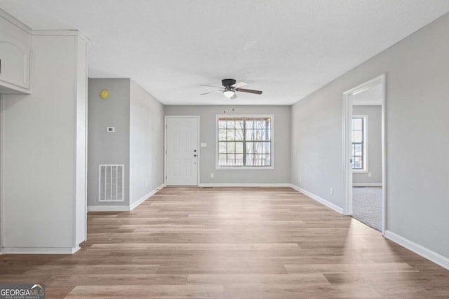 empty room with light hardwood / wood-style flooring and ceiling fan