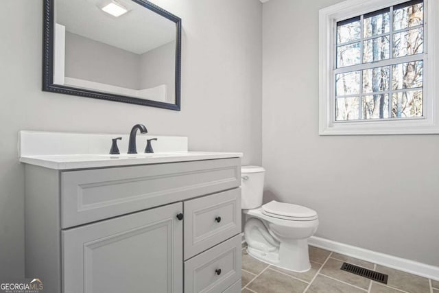 bathroom featuring tile patterned flooring, vanity, and toilet