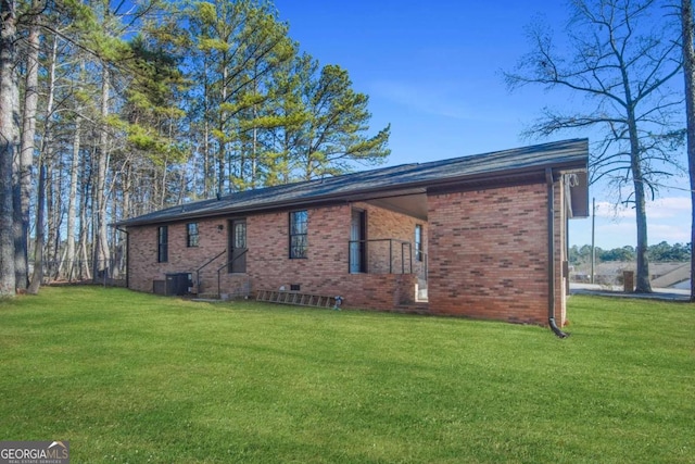 view of side of property featuring central AC unit and a lawn