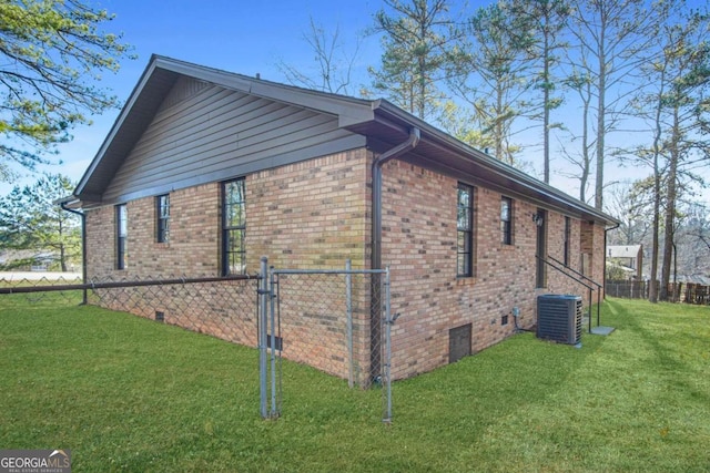 view of side of property with a lawn and central AC