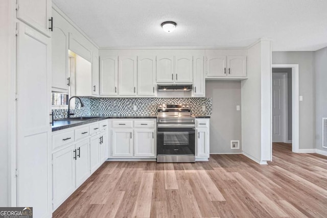 kitchen with light hardwood / wood-style floors, white cabinetry, sink, and stainless steel range