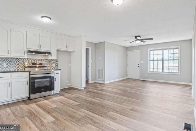 kitchen featuring electric stove, light hardwood / wood-style flooring, ceiling fan, tasteful backsplash, and white cabinetry