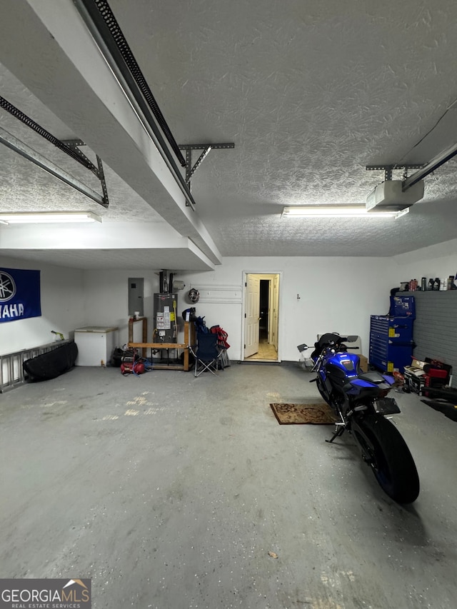 garage featuring gas water heater, a garage door opener, and electric panel