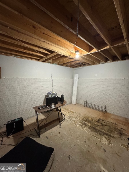 basement featuring brick wall