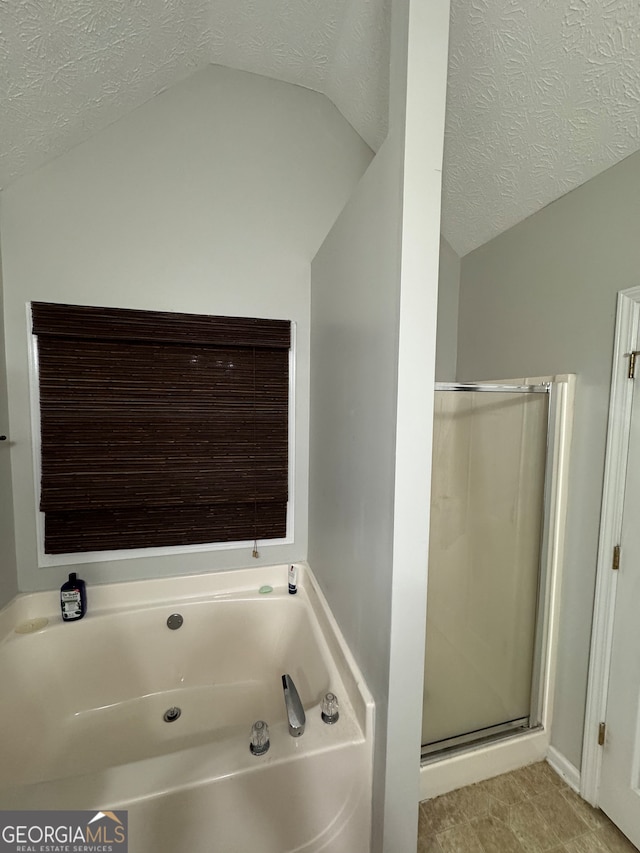 bathroom with separate shower and tub, a textured ceiling, and vaulted ceiling