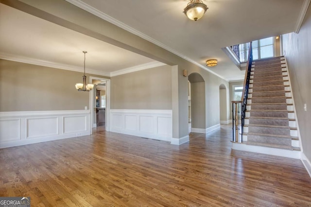 interior space with hardwood / wood-style floors, an inviting chandelier, and crown molding