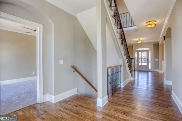 foyer featuring hardwood / wood-style floors, ceiling fan, and ornamental molding