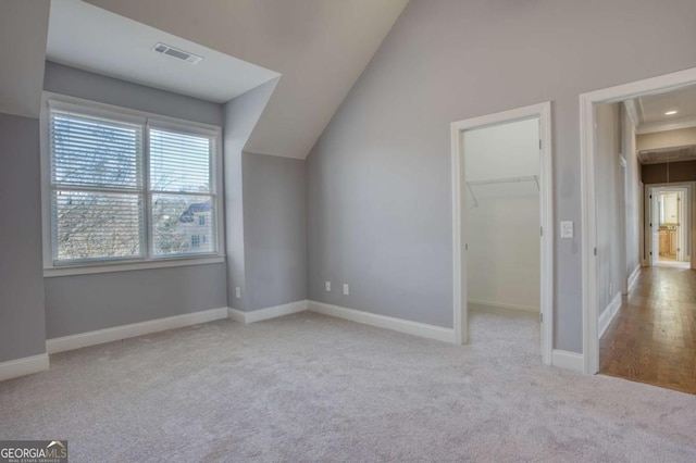 additional living space with light colored carpet and lofted ceiling