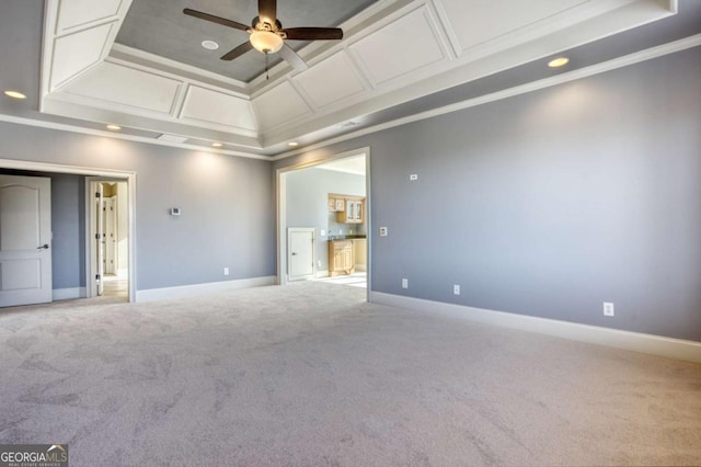 empty room with coffered ceiling, crown molding, ceiling fan, a tray ceiling, and carpet floors