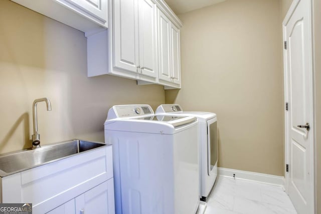 laundry room with washer and dryer, cabinets, and sink