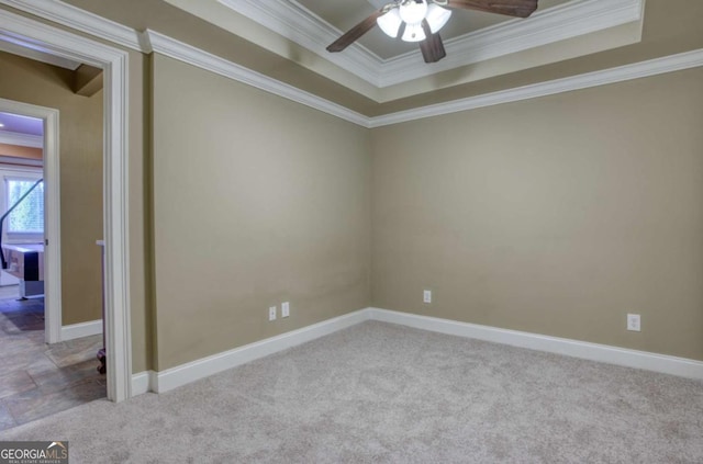 carpeted empty room featuring a tray ceiling, ceiling fan, and ornamental molding