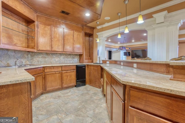 kitchen with ornate columns, crown molding, light stone counters, and decorative light fixtures