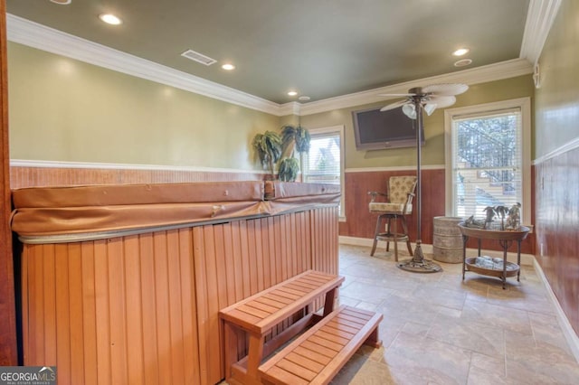 miscellaneous room featuring wooden walls, crown molding, ceiling fan, and a hot tub