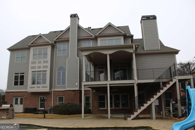 rear view of house featuring a balcony and a patio