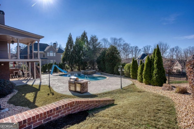 view of swimming pool with an in ground hot tub, ceiling fan, a patio area, a water slide, and a lawn