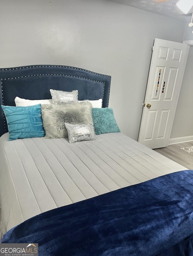 bedroom featuring wood-type flooring and a textured ceiling