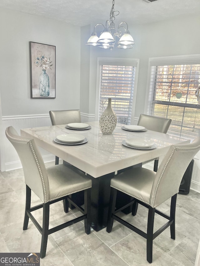 dining space featuring a textured ceiling and an inviting chandelier