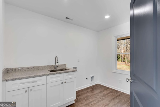 clothes washing area with sink, cabinets, electric dryer hookup, dark hardwood / wood-style flooring, and hookup for a washing machine