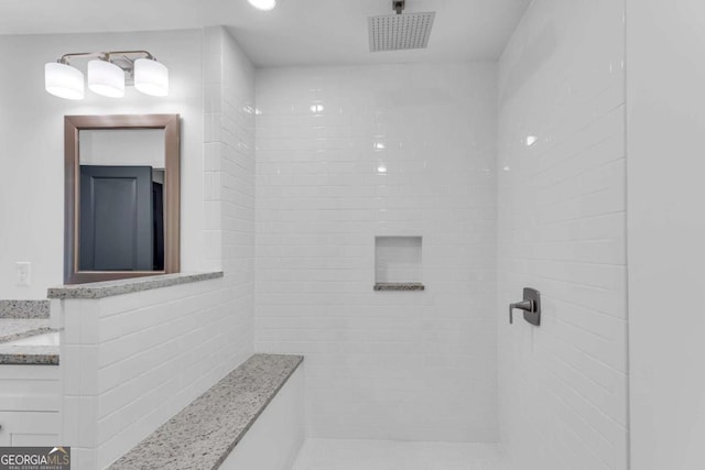 bathroom with vanity and tiled shower