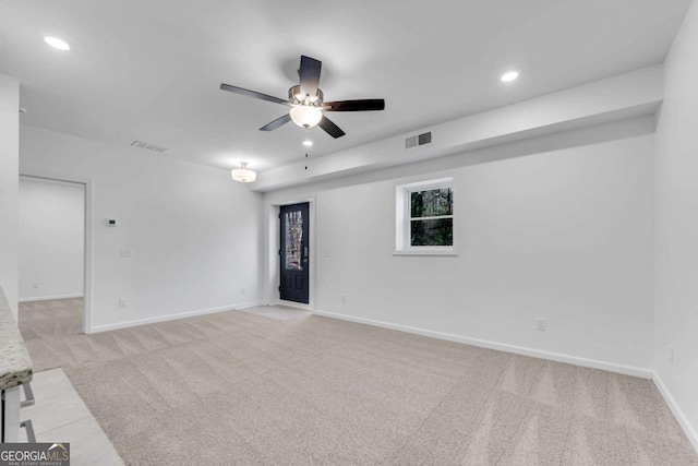 empty room with ceiling fan and light colored carpet