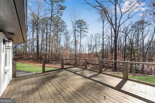 wooden deck featuring a lawn