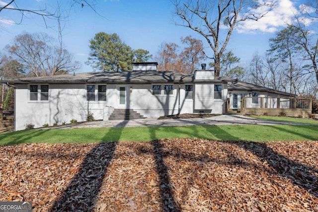 rear view of property with a lawn