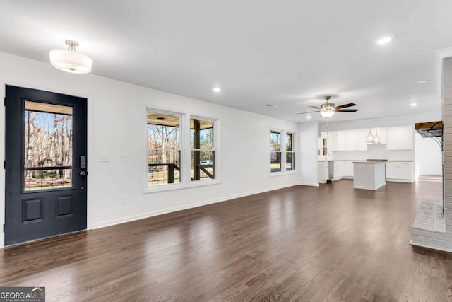 unfurnished living room featuring ceiling fan, dark hardwood / wood-style floors, and a wealth of natural light