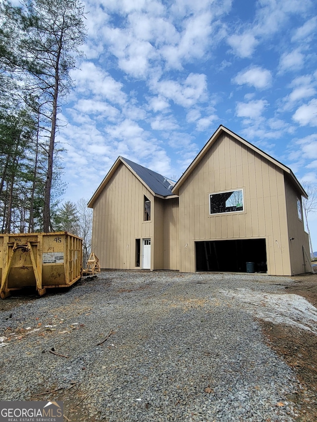 view of outdoor structure featuring gravel driveway and a garage