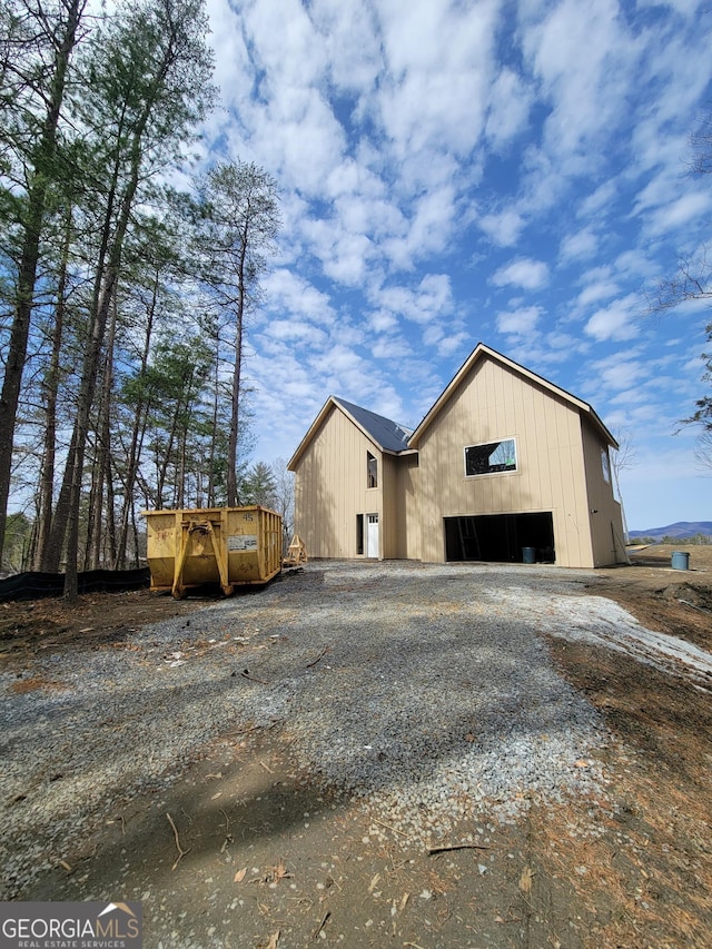 view of home's exterior featuring a garage, an outbuilding, and gravel driveway