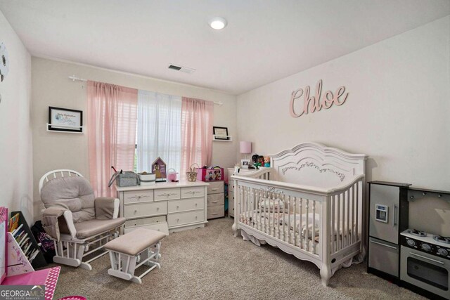 bedroom with a crib and light carpet