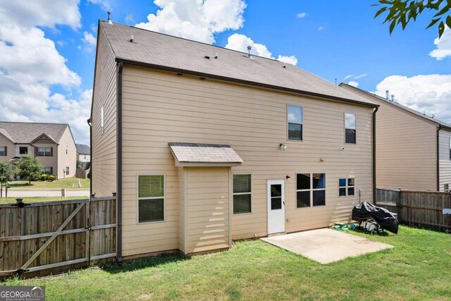 back of property with a yard and a patio